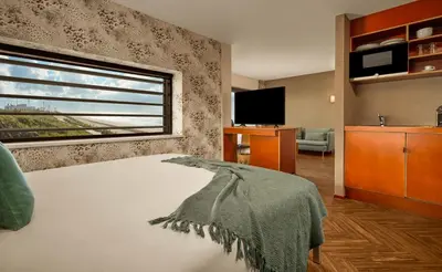 a bedroom with a bed and a large window at Beachhouse Hotel in Zandvoort