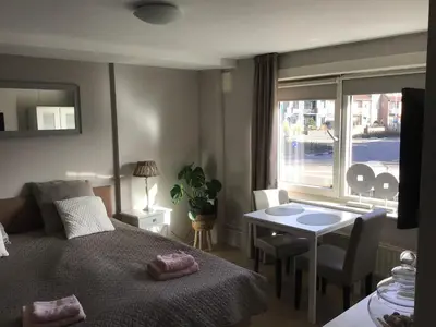 a bedroom with a bed and a table and a window at Life@Sea in Zandvoort