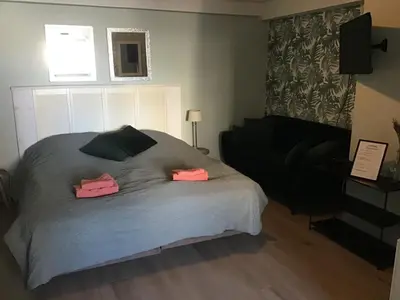 a bedroom with a bed with two pink towels on it at Life@Sea in Zandvoort