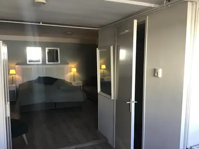 a small bedroom with a bed and a hallway at Life@Sea in Zandvoort