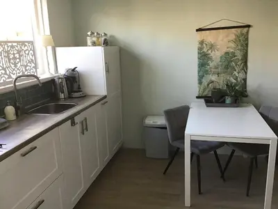 a kitchen with a sink and a table and a table and chairs at Life@Sea in Zandvoort