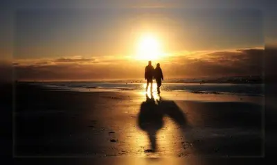 two people walking on the beach at sunset at Life@Sea in Zandvoort