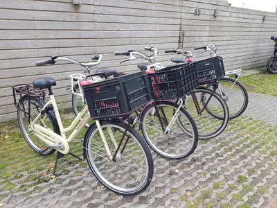 three bikes with baskets parked next to a building at Boathouse Amsterdam with bikes in Amsterdam