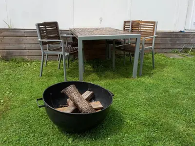 a grill with a table and chairs and a table and chairs at Boathouse Amsterdam with bikes in Amsterdam