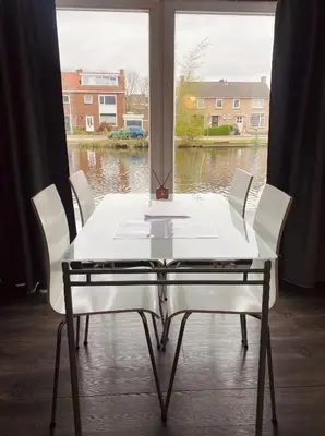a white table and chairs in front of a window at Boathouse Amsterdam with bikes in Amsterdam