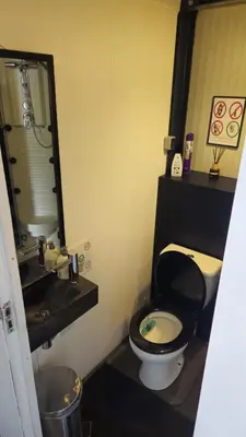 a bathroom with a black toilet and a sink at Boathouse Amsterdam with bikes in Amsterdam