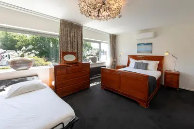 a bedroom with two beds and a window and a chandelier at Hotel La Rosa Amsterdam Beach in Zandvoort