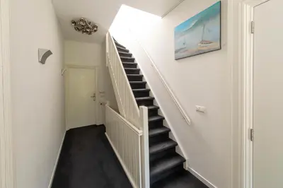 a staircase in a house with a painting on the wall at Hotel La Rosa Amsterdam Beach in Zandvoort