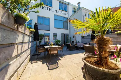 a patio at the hotel la rocca with a table and chairs at Hotel La Rosa Amsterdam Beach in Zandvoort