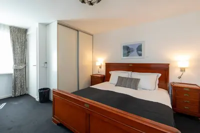 a bedroom with a large bed and two night stands at Hotel La Rosa Amsterdam Beach in Zandvoort