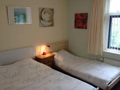 a bedroom with two beds and a lamp on a night stand at Wim's Place Schiphol Amsterdam Airport in Hoofddorp