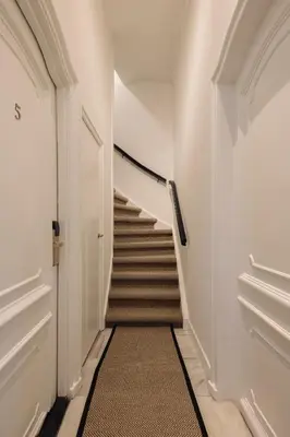 a hallway with a staircase with a carpet at Adam's Canal House in Amsterdam