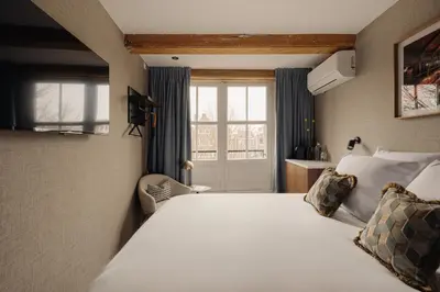 a hotel room with two beds and a window at Adam's Canal House in Amsterdam