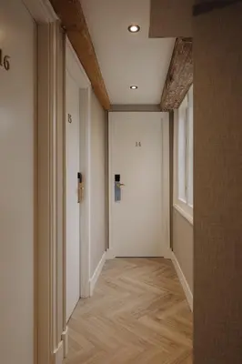 an empty hallway with a white door and wooden floors at Adam's Canal House in Amsterdam