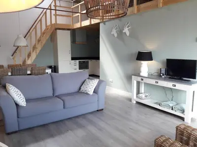 a living room with a blue couch and a television at Vecht & Weide Weesp in Weesp