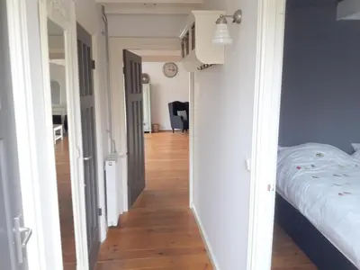 a hallway leading to a bedroom with a bed at Vecht & Weide Weesp in Weesp