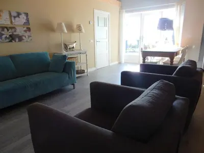 a living room with two blue couches and a piano at Vecht & Weide Weesp in Weesp