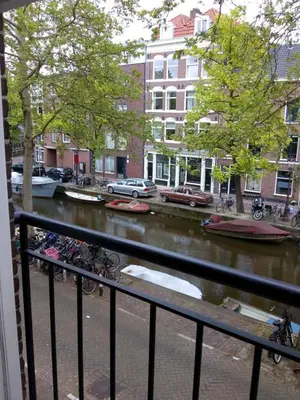 a view of a river with boats in it at Jordaan Canal View Apartment in Amsterdam