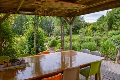 a wooden table and chairs in a garden at De Sfeerstal in Nieuwveen
