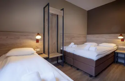 a room with two beds and a mirror at Amsterdam Downtown Hotel in Amsterdam