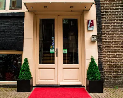 a door with a red carpet in front of a building at Amsterdam Downtown Hotel in Amsterdam