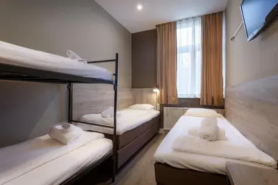 a room with three bunk beds and a window at Amsterdam Downtown Hotel in Amsterdam