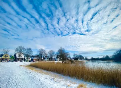 a snow covered road next to a body of water at Family House Amsterdam in Amsterdam
