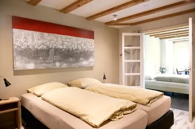 two beds in a bedroom with a painting on the wall at Family House Amsterdam in Amsterdam