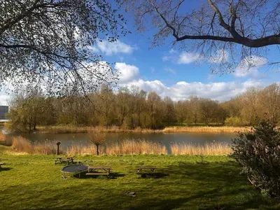 a park with picnic tables and a lake at Family House Amsterdam in Amsterdam