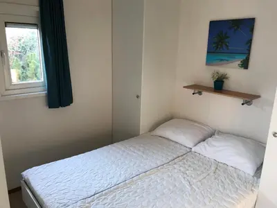 a small bedroom with a bed and a window at Blauwe Zeedistel in IJmuiden