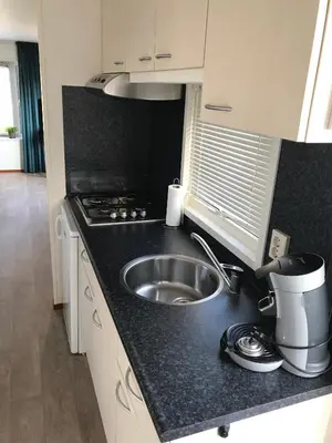a kitchen with a sink and a counter top at Blauwe Zeedistel in IJmuiden