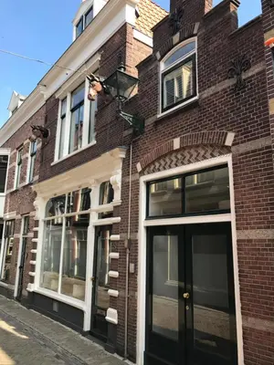 a brick building with a black door on a street at Koningshof in Alkmaar
