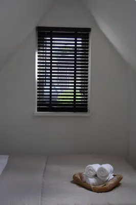 a room with a bed with a window with towels at Koningshof in Alkmaar