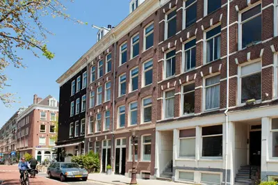 a brick building on a city street with a man on a bike at Da Costa Suite in Amsterdam