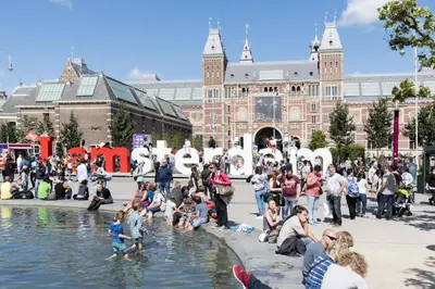 a crowd of people sitting around a fountain in front of a building at Da Costa Suite in Amsterdam