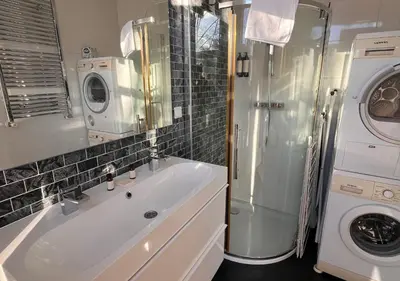a bathroom with a sink and a washing machine at Da Costa Suite in Amsterdam
