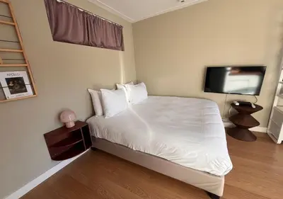 a bedroom with a bed and a flat screen tv at Da Costa Suite in Amsterdam