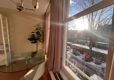 a room with a window with a table and a view at Da Costa Suite in Amsterdam