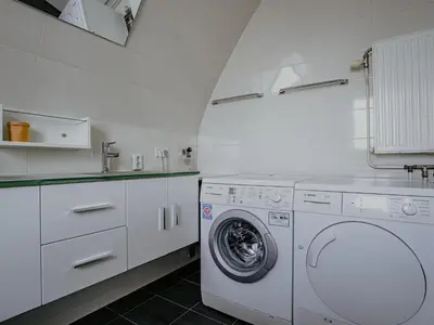 a white laundry room with a washing machine at Apartment in Egmond with Stunning Sea Views in Egmond aan Zee
