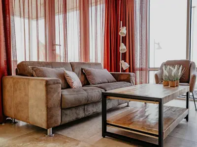 a living room with a brown couch and a coffee table at Apartment by the Beach with Sea Views in Egmond aan Zee