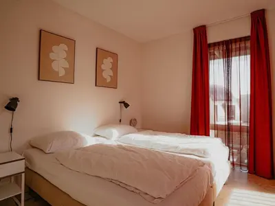 two beds in a room with red curtains at Apartment by the Beach with Sea Views in Egmond aan Zee
