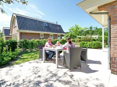 a group of women sitting at a table on a patio at Holiday Home in Noordwijk with Sunny Garden in Noordwijk aan Zee