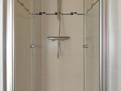 a shower with a glass door in a bathroom at Holiday Home in Noordwijk with Sunny Garden in Noordwijk aan Zee