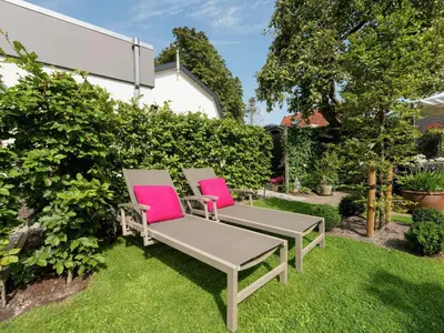 two chairs sitting on the grass in a garden at Holiday Home in Bergen near Bergerbos Forest in Bergen