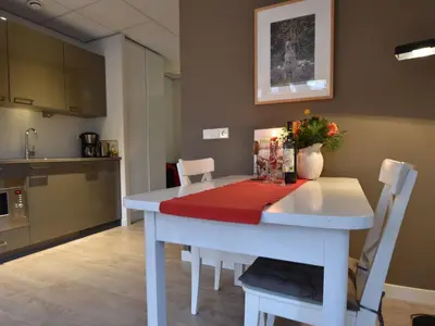 a kitchen with a white table with a red cloth on it at Holiday Home in Bergen near Bergerbos Forest in Bergen