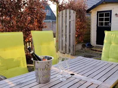 a bucket with wine bottles and glasses on a table at Holiday Home Noordwijk near the Beach in Noordwijkerhout