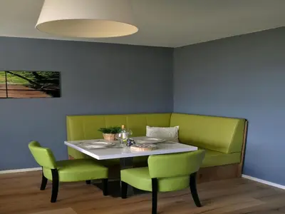 a dining room with a table and green chairs at Modern Apartment in Noordwijk near the Sea in Noordwijk