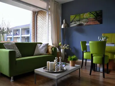 a living room with a green couch and green chairs at Modern Apartment in Noordwijk near the Sea in Noordwijk