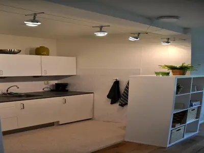 a kitchen with white cabinets and a white refrigerator at Modern Apartment in Noordwijk near the Sea in Noordwijk