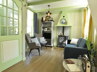 a living room with a blue couch and chairs at Cottage in Edam near IJsselmeer Lake in Edam